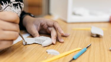 Student creating something out of clay